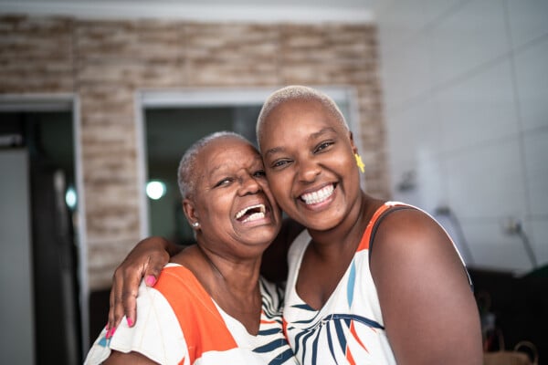 Duas mulheres se abraçando e sorrindo