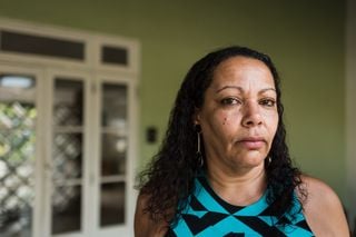 Mulher negra de pele clara, com expressão triste