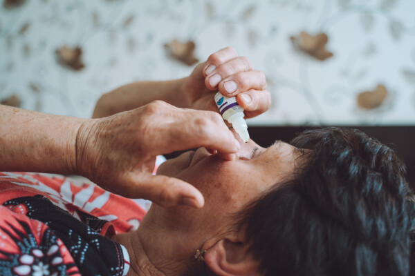 Mulher aplicando colírio nos olhos
